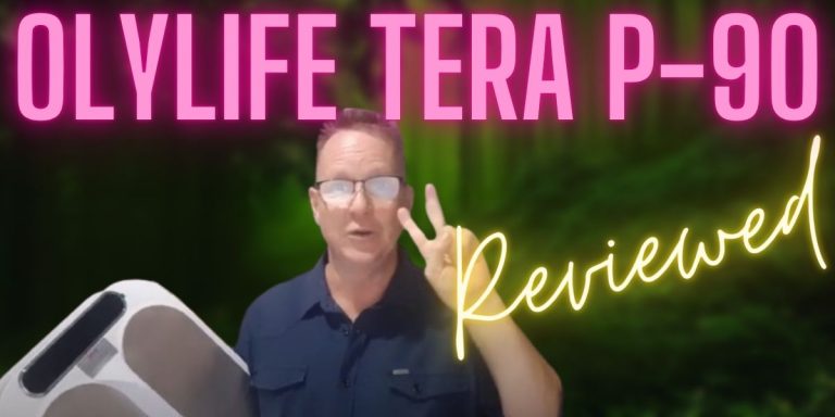 Andrew Twelftree holding the OlyLife Tera P90 device with bold text overlay: “OlyLife Tera P90 Review”