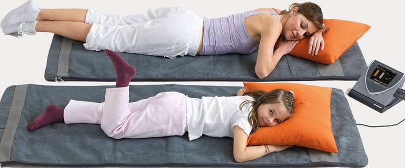 Mother and daughter using BEMER Pro PEMF mats at home