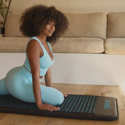 Woman stretching on HigherDOSE Go Mat placed on floor