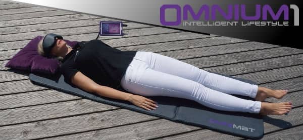 oman lying on Omnium1 PEMF mat outdoors wearing eye goggles during session