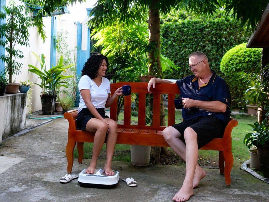 Guest enjoying an OllyLife P90 frequency therapy session while chatting over coffee at Twelftree Wellness Centre near Dumaguete.