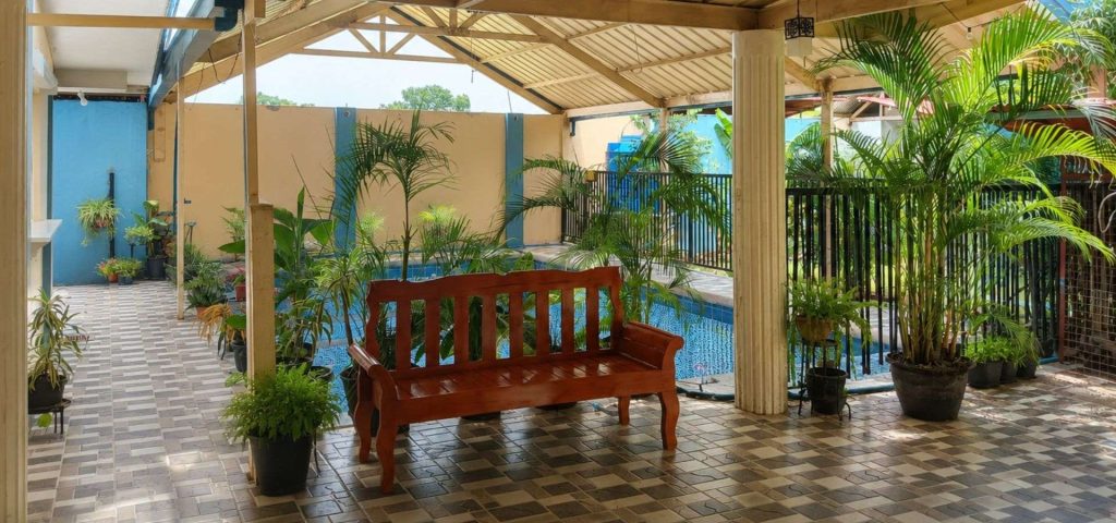 Poolside seating and tropical gardens at Twelftree Wellness Centre near Dumaguete, Negros Oriental.