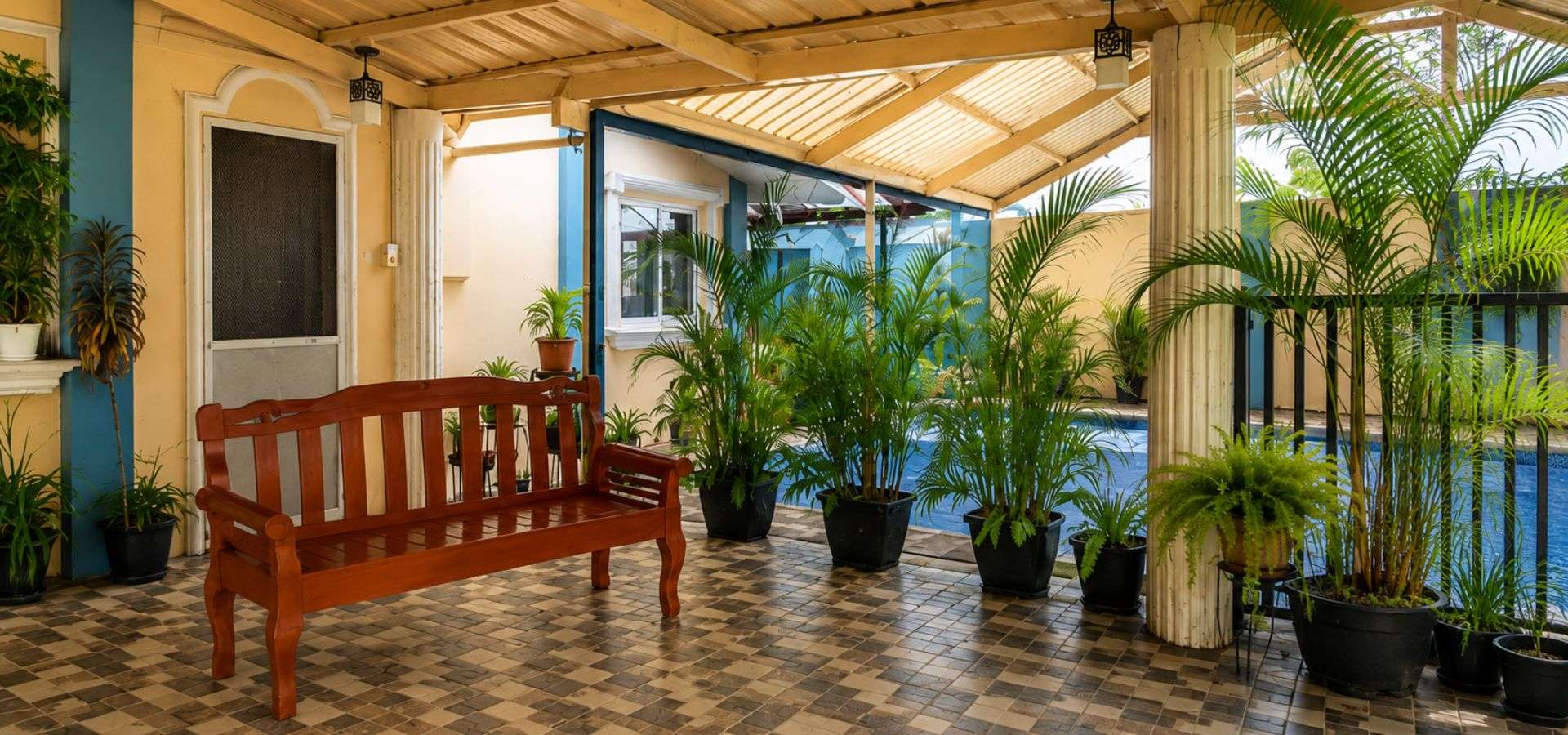 Covered outdoor therapy and relaxation area at Twelftree Wellness Centre near Dumaguete with tropical gardens and pool.